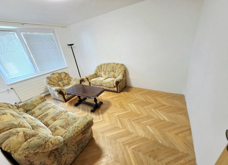 Living room in a 3-room apartment with comfortable seating and a wooden decor floor.