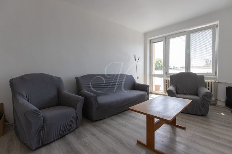 Living room in a 3-room apartment with armchairs, a sofa, and a wooden-decor floor.