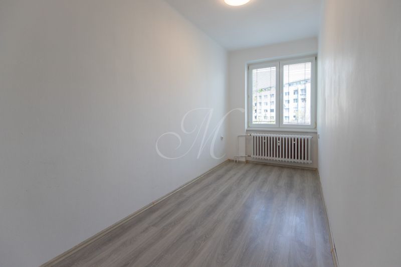 An empty room with a wood-patterned floor in a 3-room apartment.
