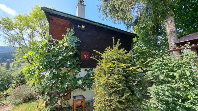 A cottage on Do Žlebín Street in Ružomberok surrounded by greenery and trees.