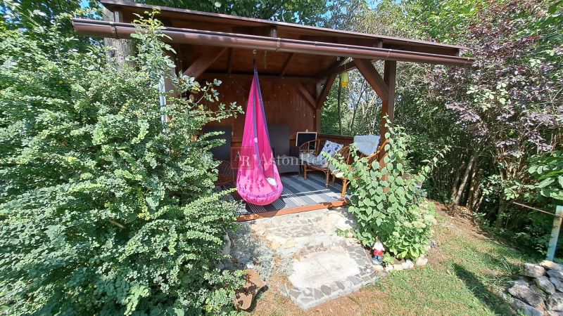 A cottage in Do Žlebín in Ružomberok with comfortable armchairs in a garden surrounded by greenery.