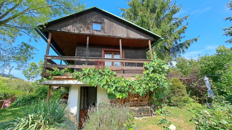 A cottage in Do Žlebín in Ružomberok surrounded by greenery and vineyards.