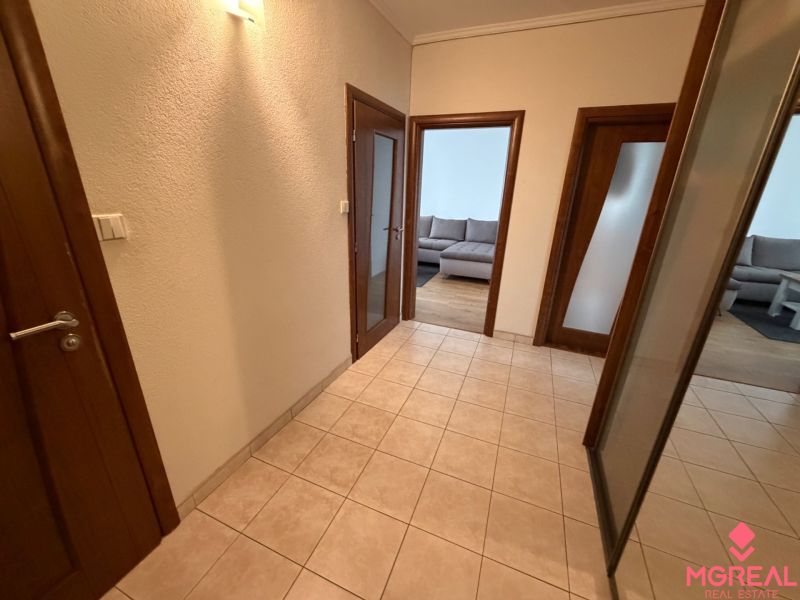 A hallway with tiles leading to the living room in a 3-room apartment.