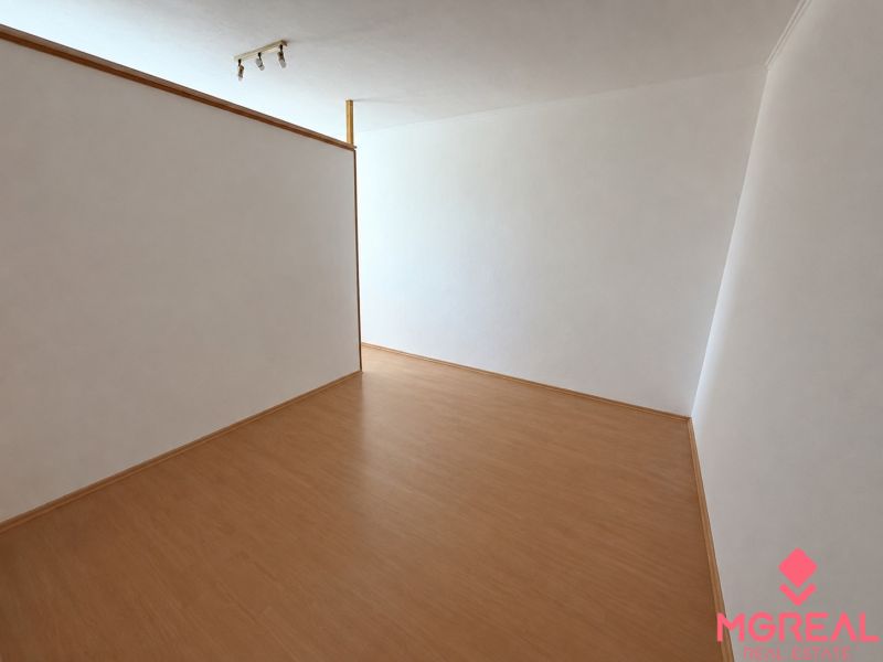 A room with white walls and a wooden decor floor in a 2-room apartment.