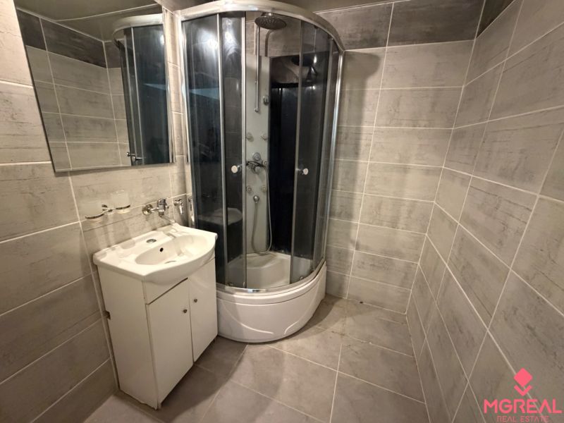 Bathroom with a sink and a shower in a 2-room apartment.