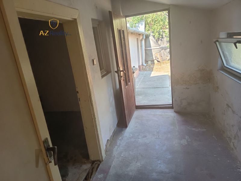 A hallway in a family house with open doors leading to the yard.