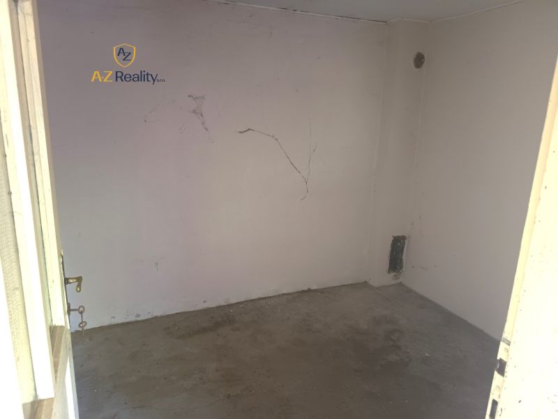 An empty room with cracked walls in a family house, suitable for renovation.