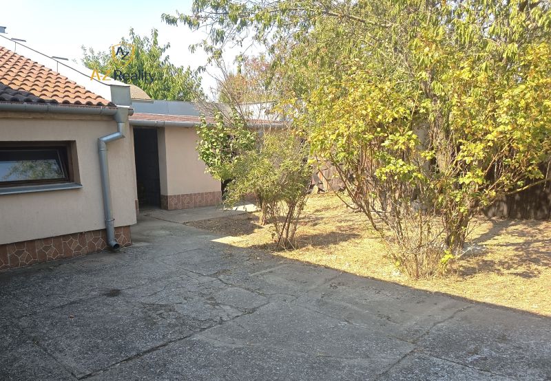 The courtyard of a family house in Nové Zámky with bushes and shrubs near the house.