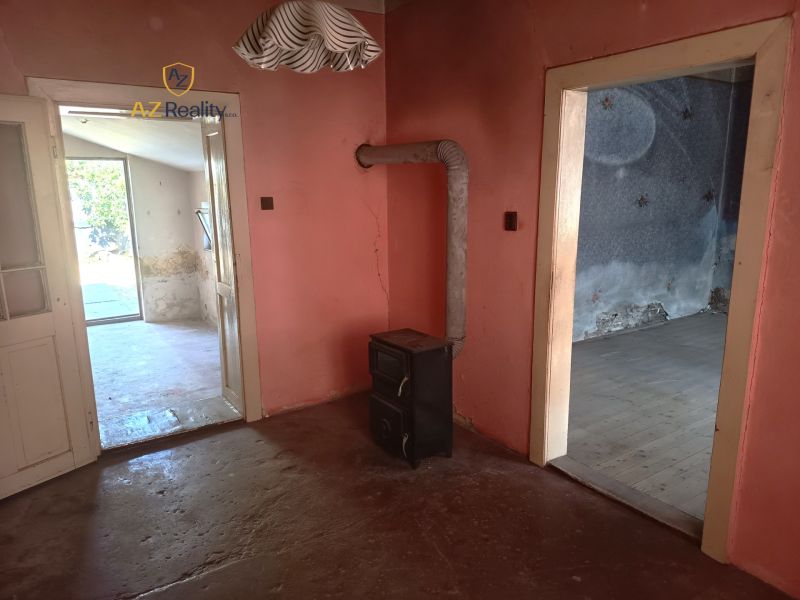 The interior of a family house with a tiled stove and spacious doors between rooms.