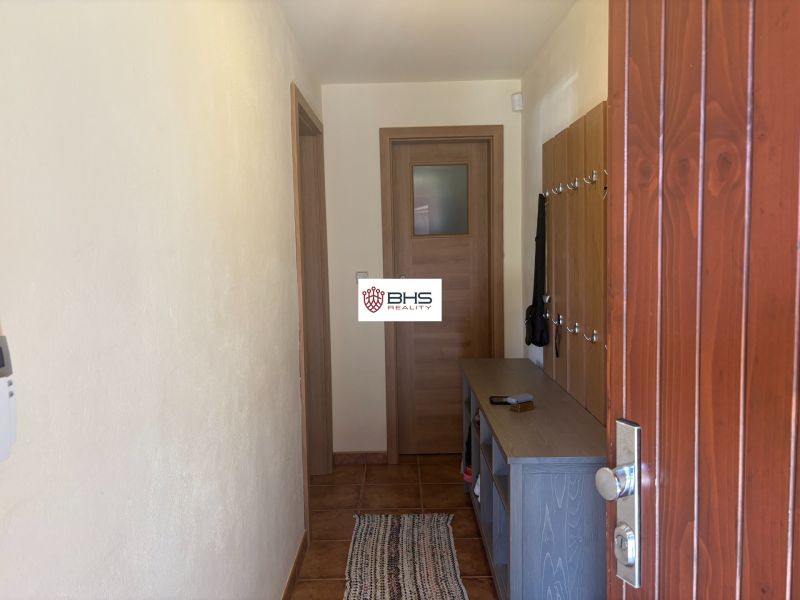 A cottage with wooden decor, an entrance hallway with a coat rack and a shoe cabinet.