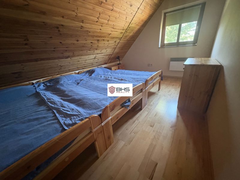 Attic room with two beds and a wooden floor decor in the cabin.