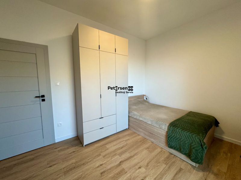 A room in a 4-room apartment with a bed, a wardrobe, and a floor with a wooden decor.