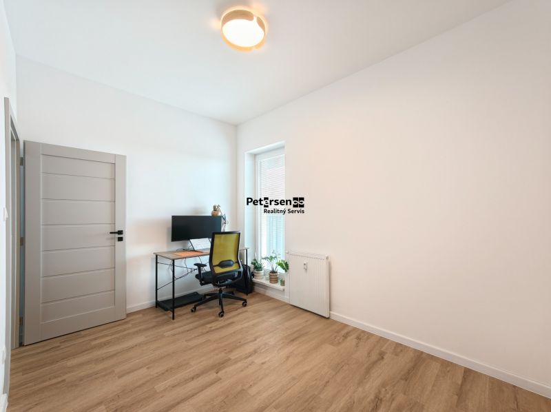 A study with a writing desk, chair, and floor with a wooden decor in a 4-room apartment.