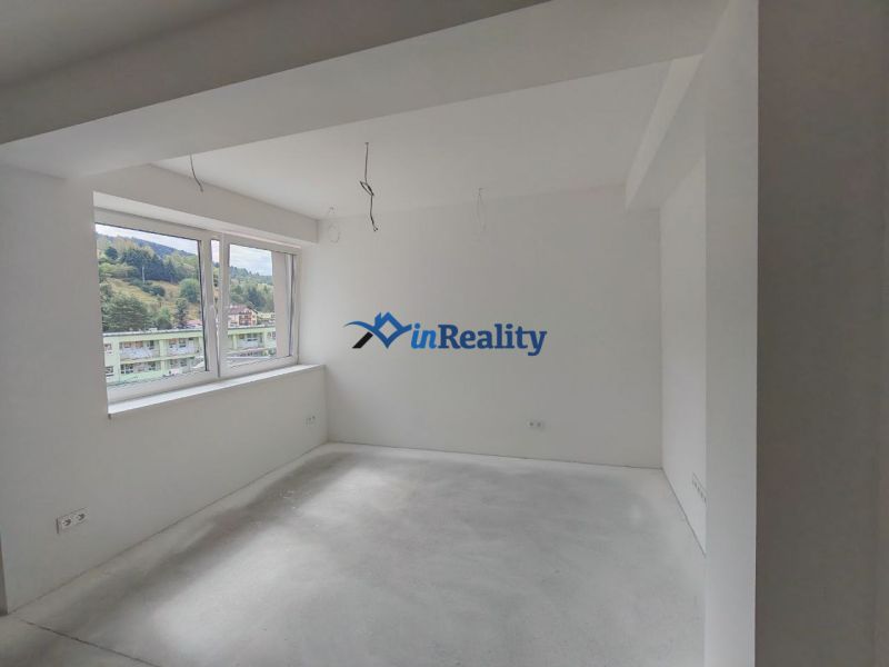 Interior of a 3-room apartment with white walls and a large window.
