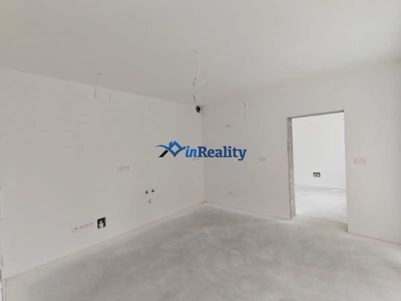 A spacious room in a 3-room apartment with white walls and preparation for electrical installations.