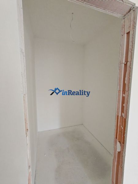 A small room without furniture in a 2-room apartment with bare walls.