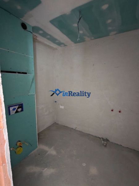 A partially finished room in a 2-room apartment with preparations for installations.