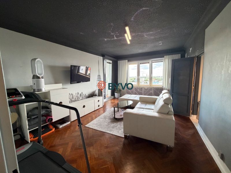 A stylishly furnished living room with a white sofa and a wooden decor floor.