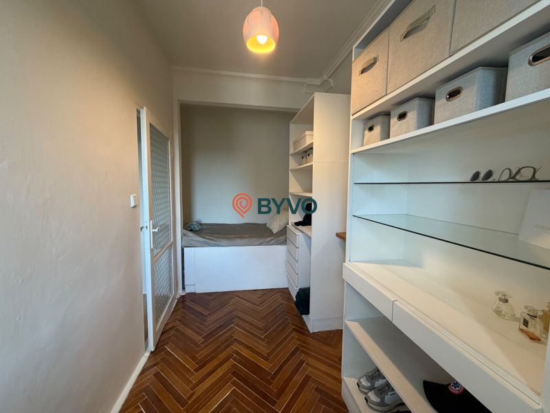 A wardrobe in a 4-room apartment with storage space and a floor with a wooden decor.