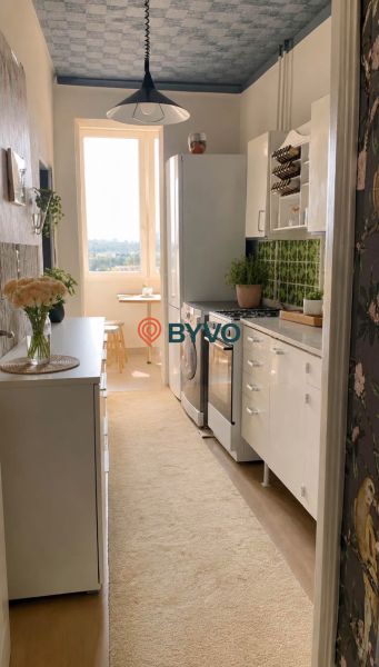 A kitchen in a 4-room apartment with white cabinets and a wood-patterned floor.