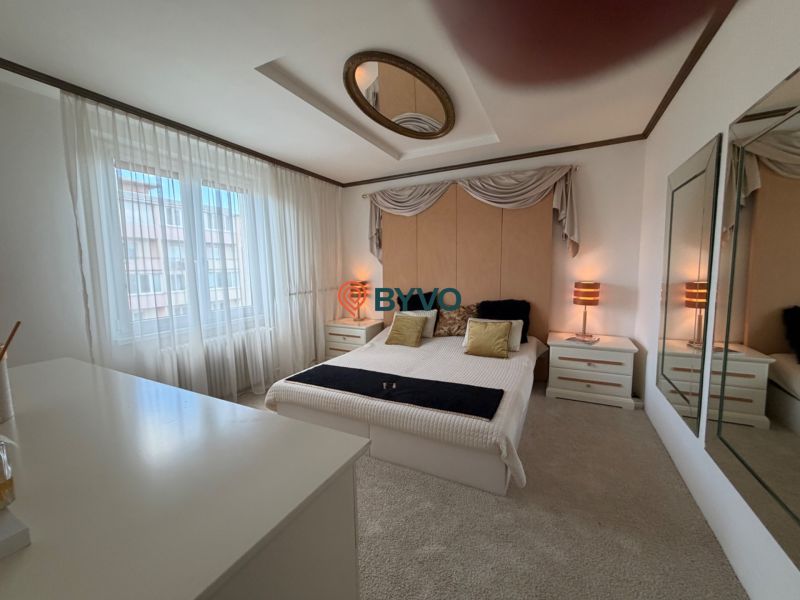 Bedroom in a 4-room apartment with a double bed, nightstands, and mirrors on the walls.
