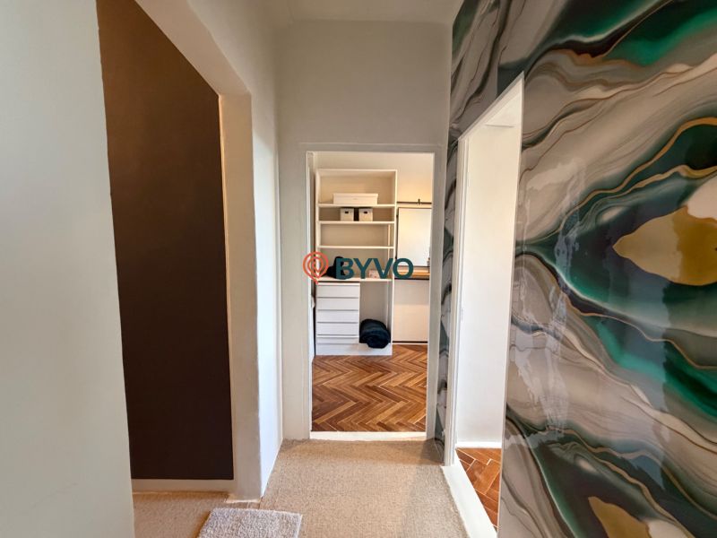 A corridor with a decorative wall and a view of a room in a 4-room apartment.