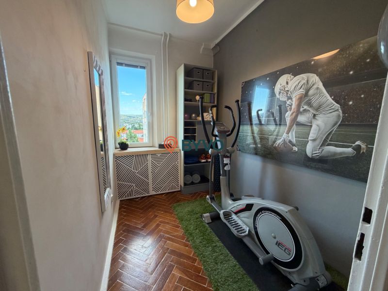 A stylish room in a 4-room apartment with exercise equipment and a decorative painting.
