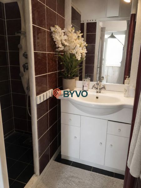 Bathroom with a shower and a white cabinet, floral decoration in a 4-room apartment.