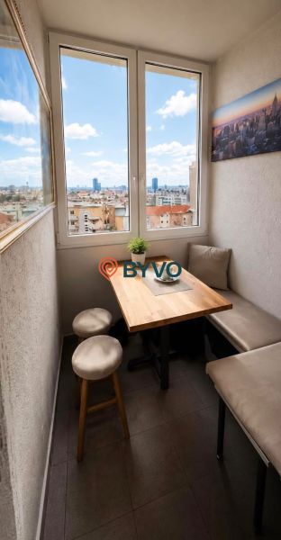 Cozy dining nook in a 4-room apartment with a view of the city and wall decoration.