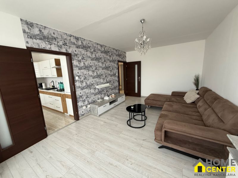 Living room in a 3-room apartment with a sofa and entrance to the kitchen.