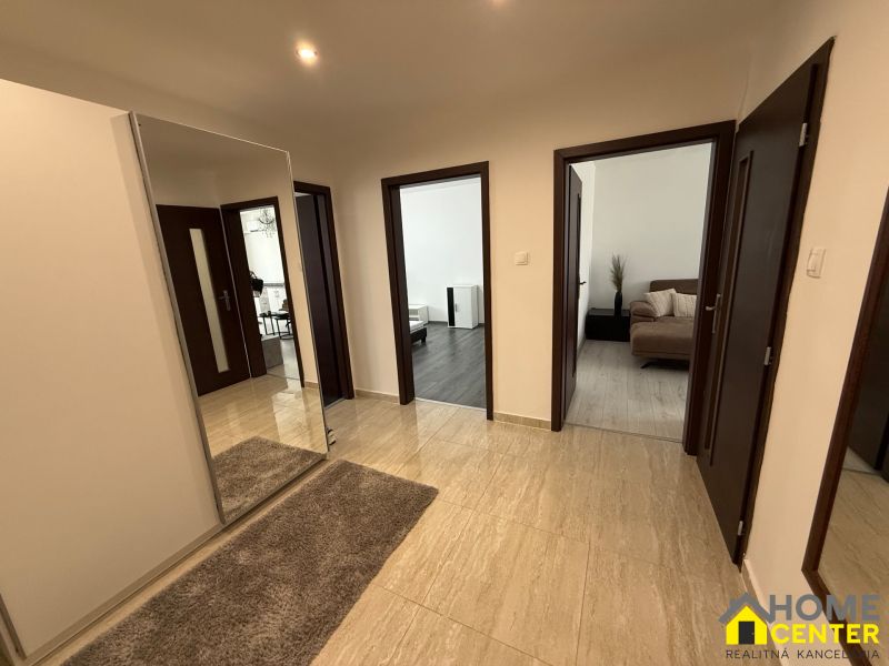 A hallway with carpet and a mirror, entrance to rooms, 3-room apartment.
