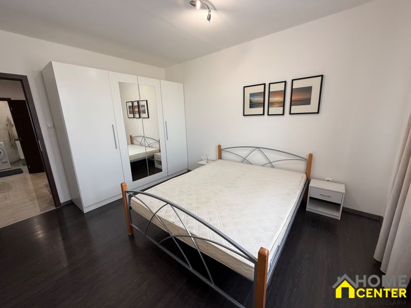A bedroom with a wood-decor floor in a 3-room apartment, equipped with a wardrobe and a bed.