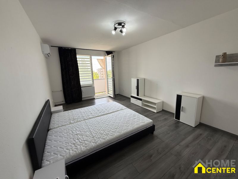 Bedroom in a 3-room apartment with wood-patterned flooring and a balcony.