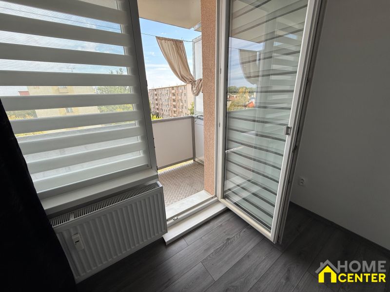 Interior with wood-patterned flooring and access to a balcony in a 3-room apartment.