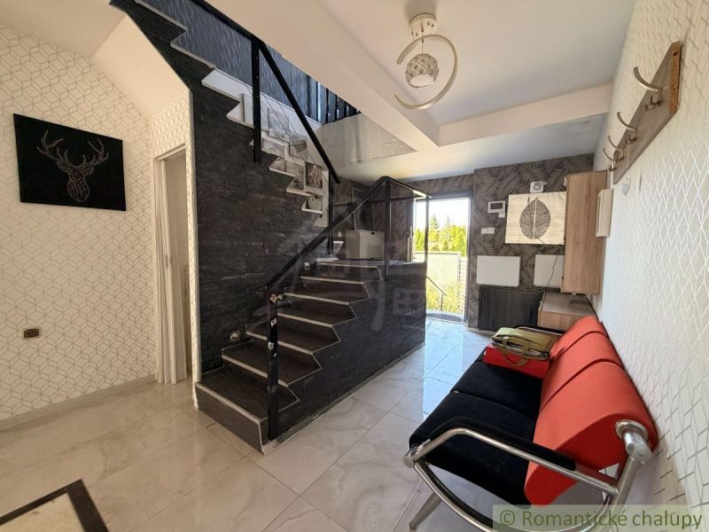 Interior of a family house with a sofa and staircase, floor with wooden decor.