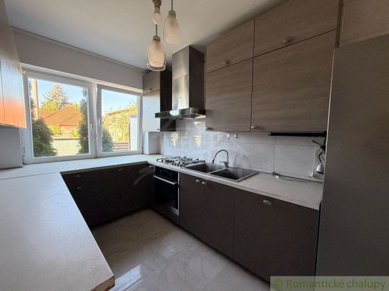 A kitchen in a family house with a view of the garden and modern kitchen appliances.