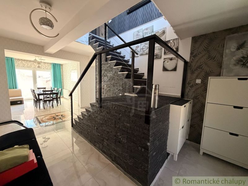 A staircase in a family house with decorative stone and a view into the dining room.