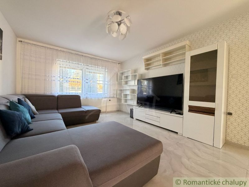 Living room with a sofa, television, and white furniture, Family house.