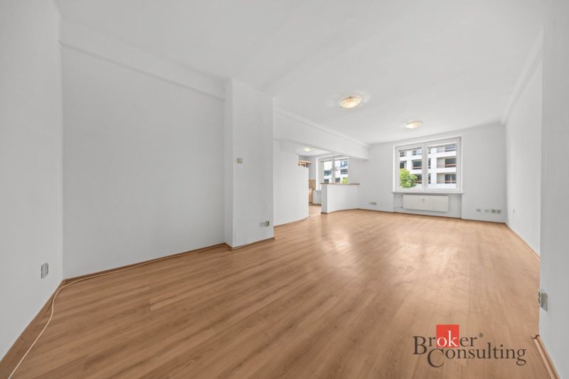 Spacious living area with wood-patterned flooring in a two-room apartment.
