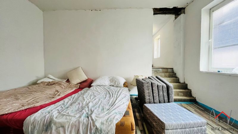 A bedroom in a family house with two beds and stairs.