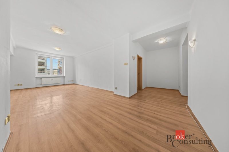 Spacious living room with wood-patterned flooring in a 2-room apartment.
