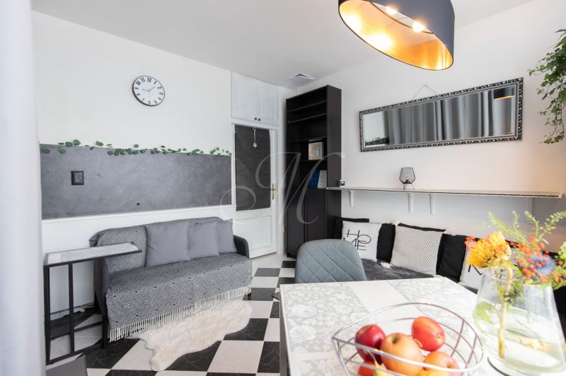 Living room in a two-room apartment with black and white flooring and decorations.
