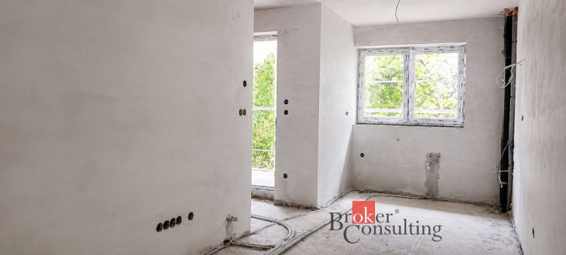 Unfinished room in a 2-room apartment with white walls and wiring.