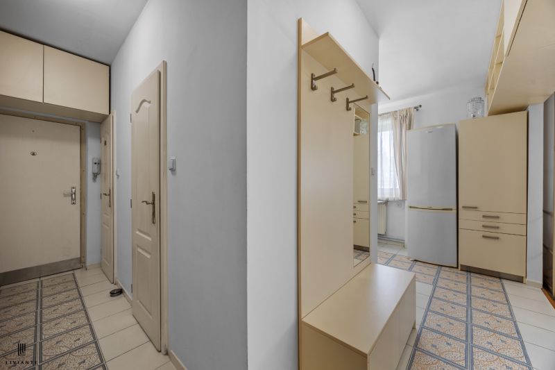 Entrance hallway in a 2-room apartment with white walls and modern furniture.