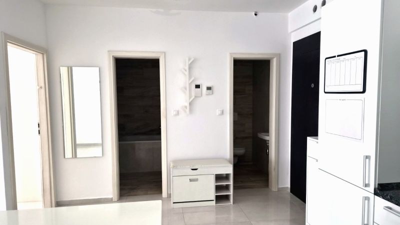 Interior of a 2-room apartment with white walls and doors to the bathroom and toilet.