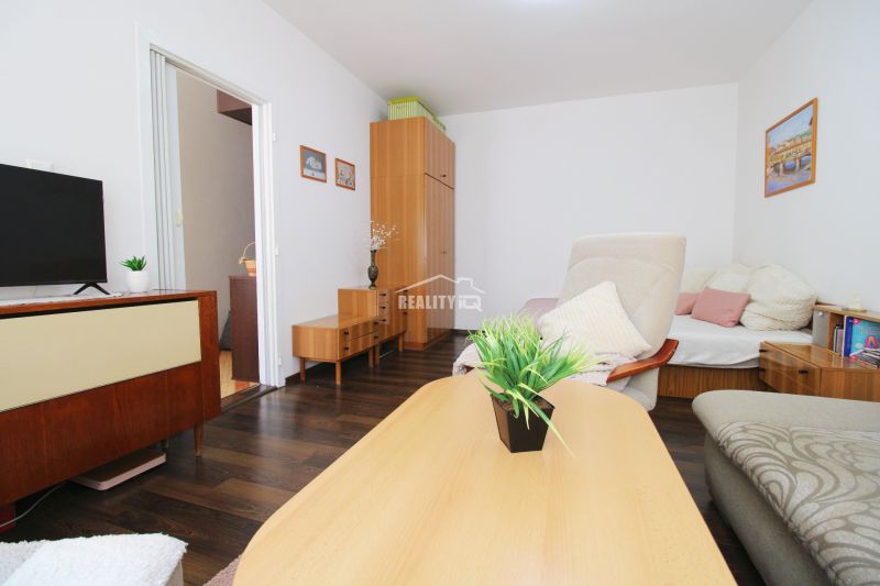 Living room in a studio apartment with a wooden decor floor and furniture.