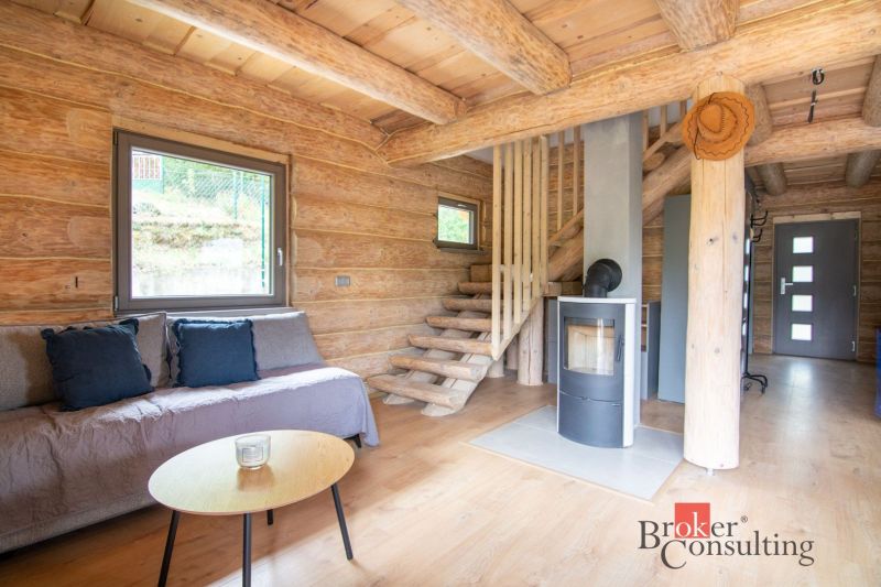 Interior of a family house with a wooden decor floor and a fireplace, solid wood stairs.