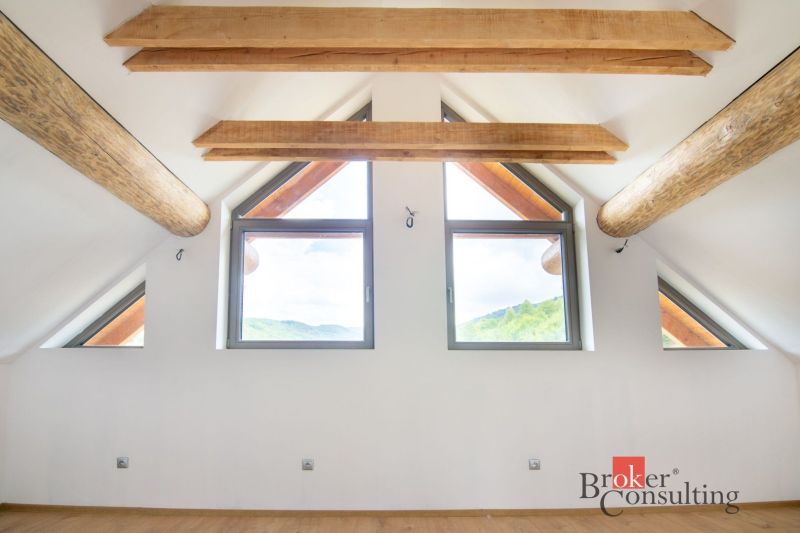 Interior of a family house with ceiling beams and a floor with a wood decor.