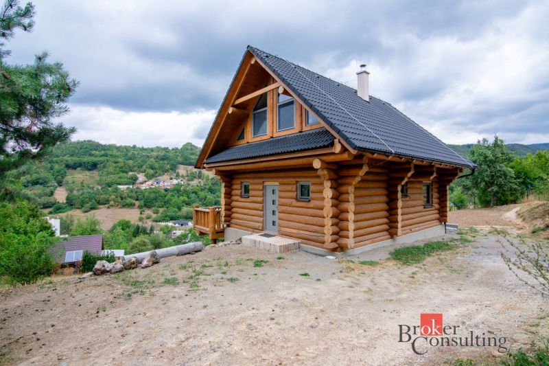 A wooden family house in the village of Vyhne surrounded by nature and hills.