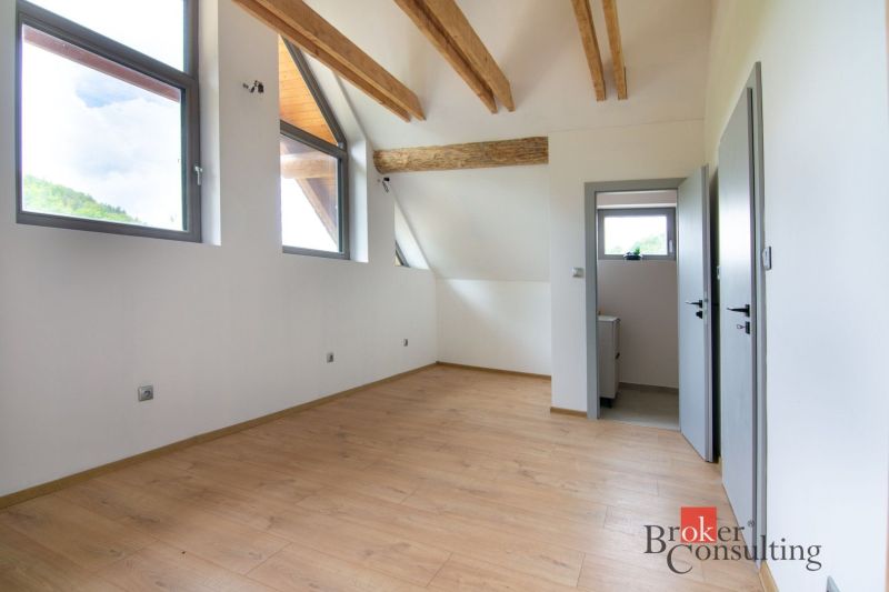 Attic room in a family house with wooden beams and a wooden decor floor.